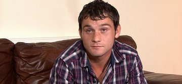 Owen wastes no time in getting his thick uncut rod to full mast and kneels up on the couch to give his cock a slow